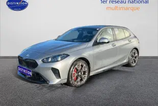 BMW Série 1 118da gris skyscraper vue 3/4 avant droit avec jantes bicolores et étriers rouges visibles.