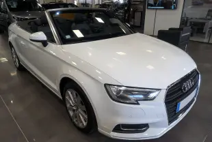 Audi A3 Cabriolet blanc vue de face avec capote ouverte, intérieur noir visible en showroom.