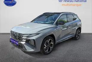 Hyundai Tucson gris shadow en 3/4 avant droit, avec calandre chromée et jantes alu distinctives.
