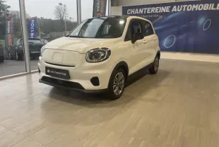 Vue 3/4 avant droite d'une LEAPMOTOR T03 Luxury blanche électrique en showroom avec phares LED et rétroviseurs noirs.