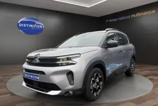 Citroën C5 Aircross hybride gris clair vue 3/4 avant droit, avec jantes distinctives et toit noir.