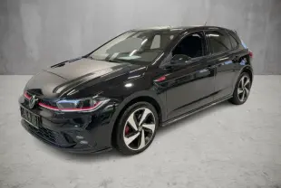 Vue 3/4 avant droite d'une Volkswagen Polo GTI noire 2024 avec jantes alliage 17 pouces et détails rouges sur la calandre.
