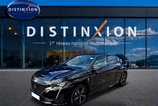Peugeot 308 1.2 hybrid 145 GT noir vue 3/4 avant, avec jantes alu et calandre distinctive devant un showroom Distinxion.