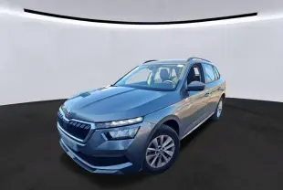 Vue 3/4 avant droite d'un Skoda Kamiq gris foncé 2023 avec calandre distinctive et toit ouvrant visible.