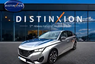 Peugeot 308 gris artense vue 3/4 avant droit, avec calandre noire et jantes alliage distinctives.