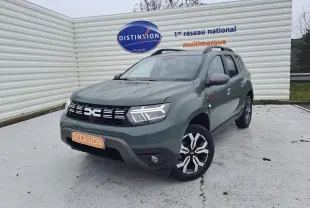 Vue 3/4 avant droite d'un Dacia Duster 2023 kaki Liken avec attelage et jantes bi-ton noires et argentées.