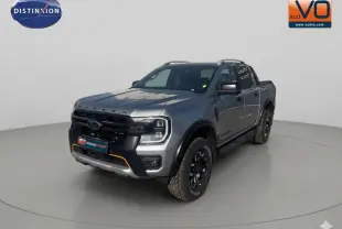 Ford Ranger gris en vue 3/4 avant droit avec barres de toit et jantes alliage noires.