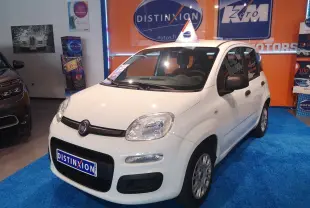 Vue 3/4 avant droite d'une Fiat Panda blanche exposée en concession avec un panneau Distinxion en arrière-plan.