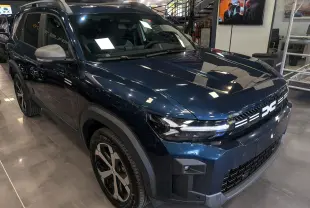Vue 3/4 avant droite du Dacia Bigster bleu indigo avec calandre lumineuse distinctive et jantes bi-ton.