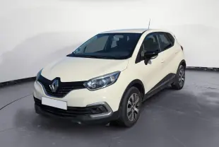 Renault Captur ivoire vue 3/4 avant droit sur parking, avec jantes alliage et calandre noire distinctive.