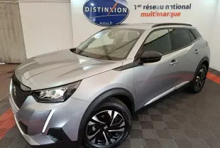 Peugeot 2008 gris clair vue 3/4 avant droit, avec jantes noires et rétroviseurs rabattables électriques.