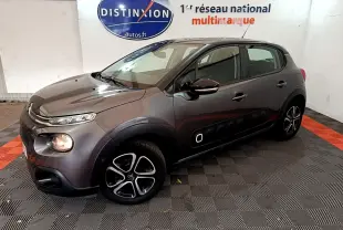 Citroën C3 gris foncé vue 3/4 avant droit, avec protections latérales noires et jantes alliage distinctives.
