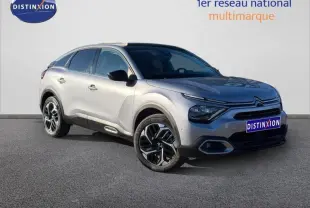 Vue 3/4 avant droite d'une Citroën C4 2024 gris acier avec jantes alliage et signature lumineuse distinctive.