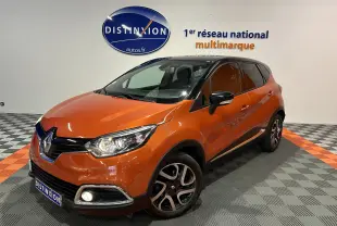 Renault Captur orange vue 3/4 avant droit, toit noir, jantes alliage et phares allumés en showroom.