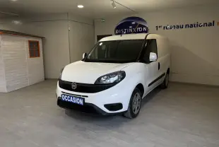 Vue 3/4 avant d’un Fiat Doblo Cargo blanc 2019 en intérieur, avec plaque « OCCASION » et logo Fiat visible.