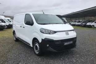 Vue 3/4 avant d’un FIAT Scudo Fourgon blanc 2024 avec pare-chocs noir et jantes acier, sur parking extérieur.