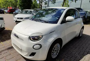 Vue 3/4 avant droite d'une FIAT 500 électrique blanche, avec phares ronds et calandre épurée.