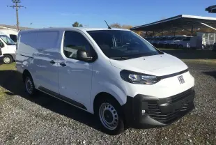 Fourgon FIAT Scudo XL blanc en 3/4 avant droit, avec pare-chocs noirs et calandre moderne sur un terrain extérieur.