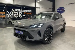 Vue 3/4 avant droit du CUPRA Formentor gris Graphene avec jantes noires et signature lumineuse Tri-LED allumée en intérieur showroom.