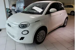 Vue 3/4 avant droite d'une Fiat 500 électrique blanche, avec phares ronds et jantes à rayons fins visibles.