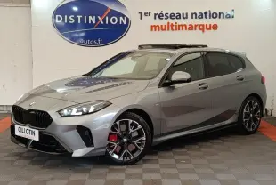 BMW Série 1 120 DKG7 M Sport gris clair vue 3/4 avant droit avec jantes noires et étriers rouges visibles