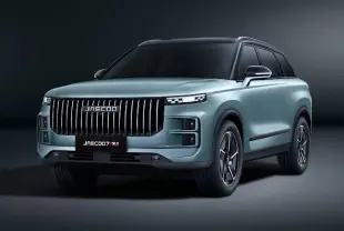 Vue 3/4 avant du SUV JAECOO J7 gris olive avec calandre verticale imposante et phares LED fins.