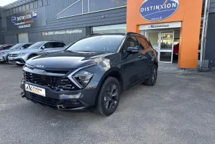 KIA Sportage gris Eclipse métallisé vu en 3/4 avant droit devant un garage Distinxion.