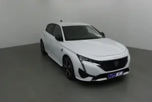 Peugeot 308 blanc Okenite vue 3/4 avant droit, avec calandre noire et feux LED en forme de griffes.