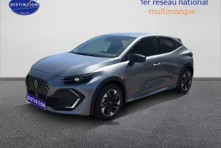 Renault Clio VI gris schiste en 3/4 avant droit, avec jantes alliage et phares LED allumés.