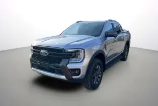 Ford Ranger 2.0 Wildtrak Plus gris iconic en 3/4 avant droit avec barres de toit et jantes alu 18 pouces.
