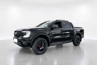 Ford Ranger Wildtrak Plus noir agate en 3/4 avant droit, avec jantes noires et barres de toit visibles.