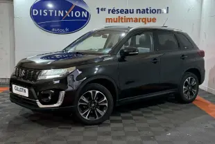 Suzuki Vitara noir en vue 3/4 avant droit, avec jantes alliage et calandre chromée brillante.