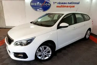 Peugeot 308 break blanc vue 3/4 avant droit dans un showroom avec logo Distinxion en arrière-plan.