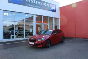 BMW Série 1 118d rouge Melbourne métallisé vue 3/4 avant droit, avec jantes alliage et becquet arrière M Sport.