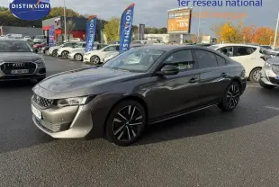 Peugeot 508 gris platinium en 3/4 avant droit, avec jantes noires et détails chromés visibles au soleil.