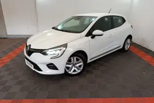 Renault Clio Business TCe 90 blanche vue 3/4 avant droit, avec feux LED allumés dans un garage.