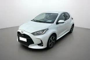 Toyota Yaris 2025 blanc lunaire vue 3/4 avant droit avec calandre noire et jantes alliage bicolores.