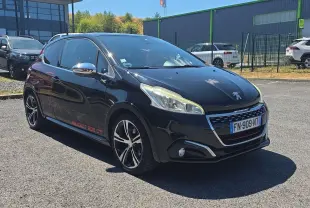 Peugeot 208 GTI noire vue 3/4 avant droit avec jantes alliage 17” et stickers rouges sur la portière arrière.