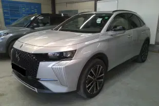 DS7 2025 Cristal Pearl en 3/4 avant droit, avec calandre noire distinctive et jantes alliage noires.