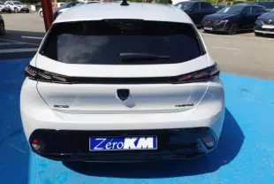 Vue arrière d'une Peugeot 308 Hybrid blanche Okénite avec feux arrière LED et lunette arrière surteintée.