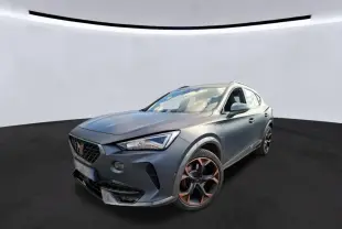 Vue 3/4 avant d’un CUPRA Formentor 1.4 E-HYBRID 245 DSG6 VZ gris foncé mat avec jantes noires et accents cuivrés.