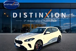 BMW Série 1 blanc alpin vue 3/4 avant droit, jantes 18 pouces bicolores et calandre noire M Sport.