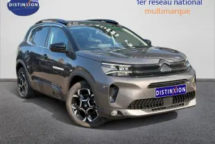 Citroën C5 Aircross gris Platinium vue 3/4 avant droit avec jantes alu et barres de toit visibles.