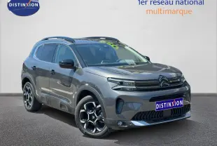 Citroën C5 Aircross gris Platinium vue 3/4 avant droit avec jantes alu et barres de toit visibles.