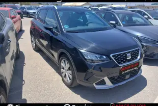 SEAT Arona noir vue 3/4 avant droit, avec calandre chromée et jantes alliage visibles en extérieur.
