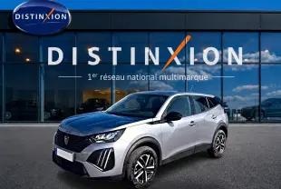Peugeot 2008 gris 3/4 avant droit avec toit noir et jantes distinctives, devant showroom Distinxion.