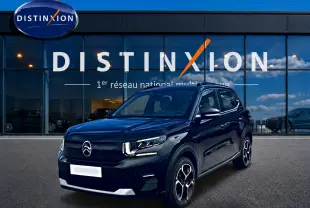 Citroën C3 113 Plus électrique noire vue 3/4 avant, avec jantes distinctives et calandre épurée devant showroom Distinxion.