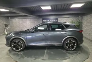 Vue de profil côté gauche du CUPRA Formentor gris, soulignant ses jantes alliage noires et détails de carrosserie sportifs.