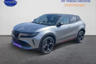 Vue 3/4 avant droite d'une Alfa Romeo Junior 1.2 hybride gris clair avec jantes noires et toit noir.