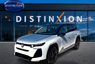 Vue 3/4 avant d'un Citroën C5 Aircross 2026 blanc avec toit noir et jantes alliage noires devant un showroom Distinxion.